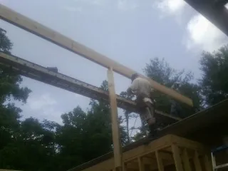 Carpenter setting a ridge beam over a new addition frame — Ice Dam Removal by Roofing Brothers in Highland Mills