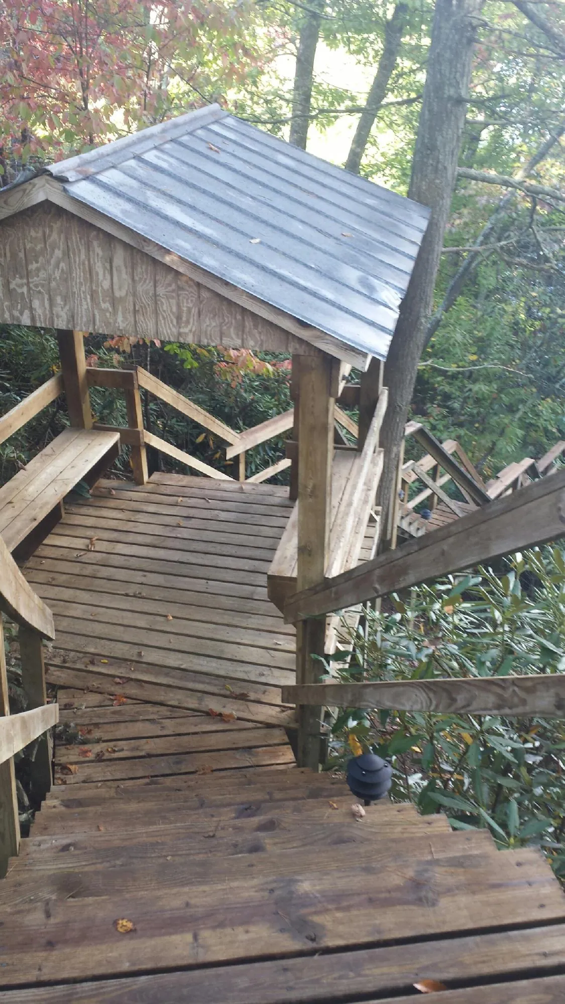 Metal roofed shelter over wooden steps on a wooded walkway — Skylight Repair & Installation work by our crew in Highland Mills