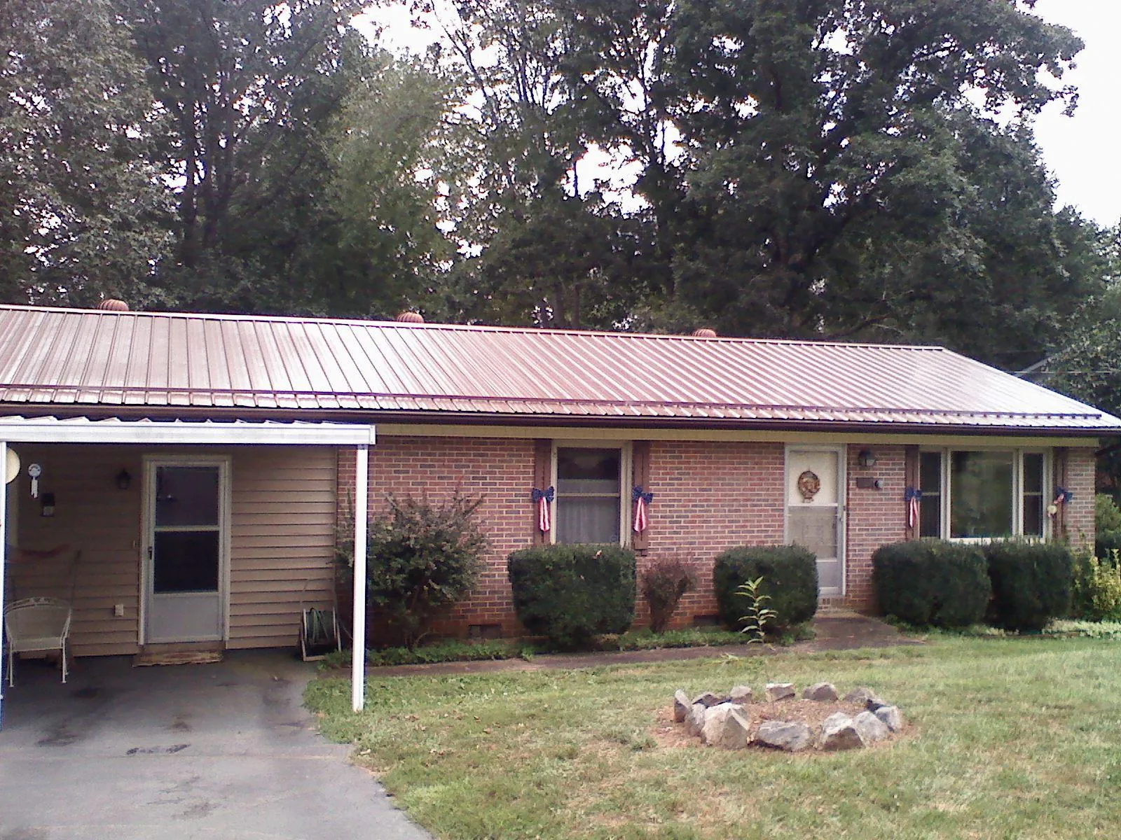 Bronze metal roof and carport on a brick ranch home — Roof Repair work by our crew in Highland Mills